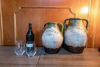 three bottles and wine glasses sitting on a table at HB Hideaway Boho Treehouse Vibes in the Pines in Shaver Lake