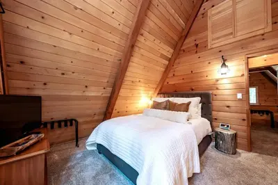 a bedroom in a log cabin with a bed at HB Hideaway Boho Treehouse Vibes in the Pines in Shaver Lake