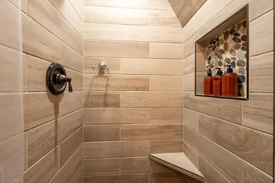 a tiled shower with a niche with bottles of wine at HB Hideaway Boho Treehouse Vibes in the Pines in Shaver Lake