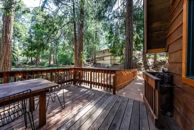 a wooden deck with a table and benches on it at HB Hideaway Boho Treehouse Vibes in the Pines in Shaver Lake