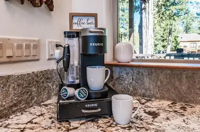 a coffee maker and two cups on a counter at Leopard Lily Lodge Luxe Stays 2 Suites AC in Shaver Lake