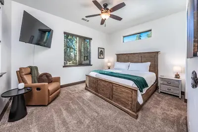 a bedroom with a bed and a chair at Leopard Lily Lodge Luxe Stays 2 Suites AC in Shaver Lake