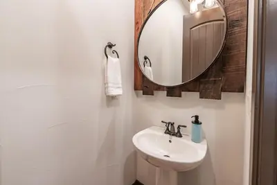 a bathroom with a sink and a mirror at Leopard Lily Lodge Luxe Stays 2 Suites AC in Shaver Lake