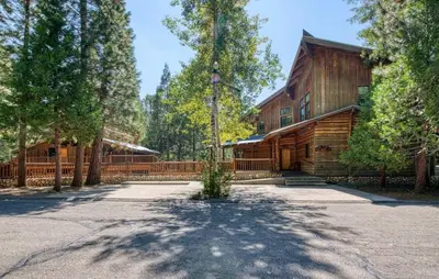 a home in the woods with a driveway at Waterfall Lodge Yellowstone Vibes AC Space in Shaver Lake