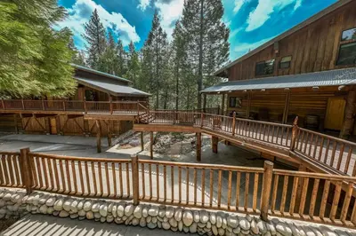 a large deck next to a log cabin at Waterfall Lodge Yellowstone Vibes AC Space in Shaver Lake