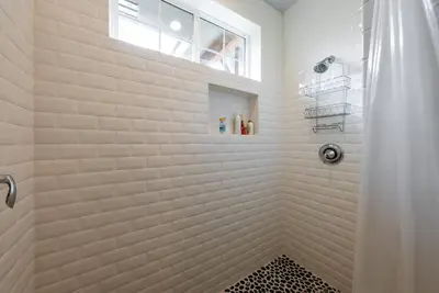 a white bathroom with a shower with a window at The Great Escape Sunsets Hot Tub Bliss in Shaver Lake