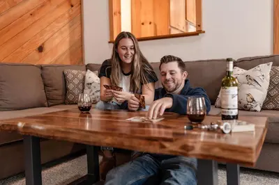 a man and a woman sitting at a table with wine glasses at The Knotty Sparrow Prime Spot Smores Nights in Shaver Lake