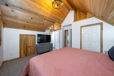 a bedroom with a bed and a flat screen tv at The Knotty Sparrow Prime Spot Smores Nights in Shaver Lake