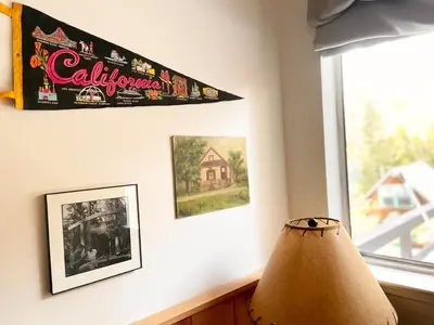 a lamp in a room with a window and pictures at The Cedar House Prime Spot Kayaks & Cool AC in Shaver Lake
