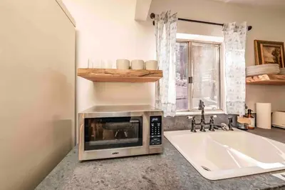 a kitchen with a microwave and a sink at The Cedar House Prime Spot Kayaks & Cool AC in Shaver Lake