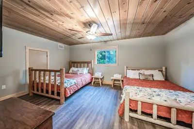 a bedroom with two beds and a wooden ceiling at The Sparrows Nest Cozy Charm Fire Pit Fun in Shaver Lake