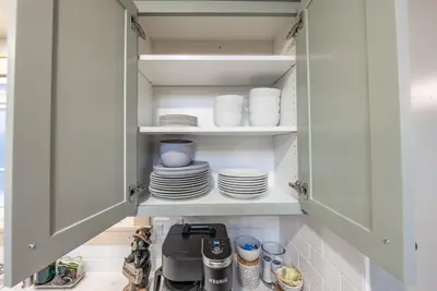 a cupboard filled with plates and dishes in a kitchen at The Sparrows Nest Cozy Charm Fire Pit Fun in Shaver Lake