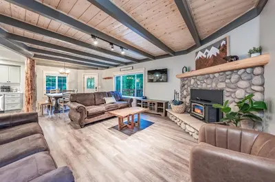 a living room with couches and a stone fireplace at The Sparrows Nest Cozy Charm Fire Pit Fun in Shaver Lake