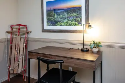 a desk in a room with a lamp and a painting at Shady Pines Smores, Stars & Cozy Nights In in Shaver Lake