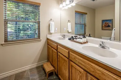 a bathroom with two sinks and a large mirror at Shady Pines Smores, Stars & Cozy Nights In in Shaver Lake