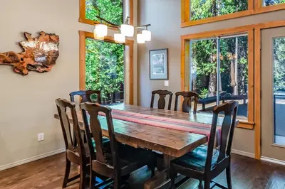 a dining room with a wooden table and chairs at Shady Pines Smores, Stars & Cozy Nights In in Shaver Lake