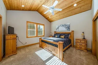 a bedroom with a bed and a ceiling fan at Sierra Pines Villa Deck Jetted Tub Game Rm in Shaver Lake