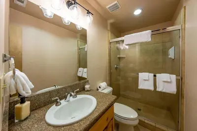 a bathroom with a sink and a toilet and a shower at Sierra Pines Villa Deck Jetted Tub Game Rm in Shaver Lake