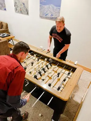 two men standing around a table with a giant chessboard at Sierra Pines Villa Deck Jetted Tub Game Rm in Shaver Lake