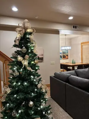a christmas tree in a living room next to a couch at Sierra Pines Villa Deck Jetted Tub Game Rm in Shaver Lake