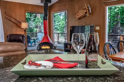 a tray with a bottle of wine and glasses on a counter at Mystic Meadow Sweet Cabin Meadow Views in Shaver Lake
