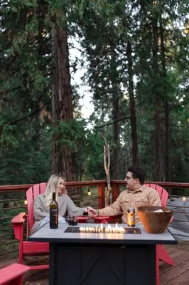 a man and woman sitting at a table with candles at Mystic Meadow Sweet Cabin Meadow Views in Shaver Lake