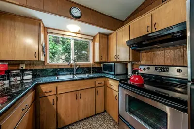 a kitchen with wooden cabinets and a stove top oven at Mystic Meadow Sweet Cabin Meadow Views in Shaver Lake