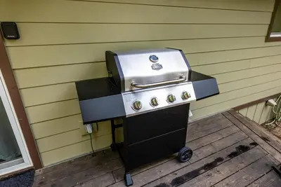 a grill sitting on a deck next to a wall at Mystic Meadow Sweet Cabin Meadow Views in Shaver Lake