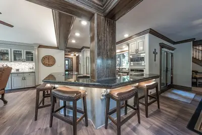 a kitchen with a large island with bar stools at Lux Western Cabin Pool Table Ping Pong Vibes in Shaver Lake