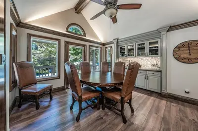 a dining room with a table and chairs and a clock at Lux Western Cabin Pool Table Ping Pong Vibes in Shaver Lake