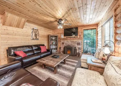 a living room with a couch and a fireplace at The Stew Cabin Cozy Escape Fireside Memories in Shaver Lake