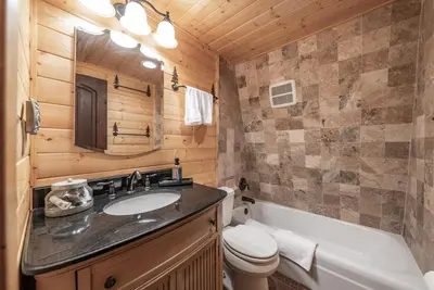 a bathroom with a sink and a toilet and a tub at The Stew Cabin Cozy Escape Fireside Memories in Shaver Lake