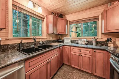 a kitchen with wooden cabinets and a sink at The Stew Cabin Cozy Escape Fireside Memories in Shaver Lake