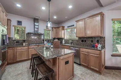 a kitchen with wooden cabinets and granite counter tops at The Chalet at Shaver Lake We Have it ALL! in Shaver Lake
