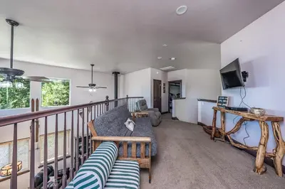 a living room with a couch and a tv on a balcony at The Chalet at Shaver Lake We Have it ALL! in Shaver Lake