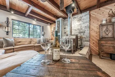 a room with a bed and two wine glasses on a table at Ridgeview Retreat Location Meets Comfort AC! in Shaver Lake