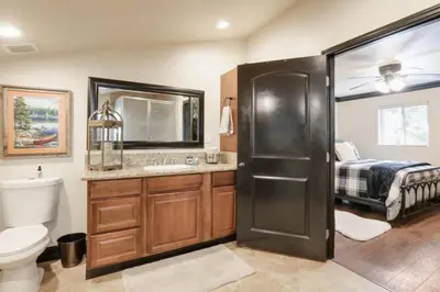 a bathroom with a sink and a toilet and a bed at Hibernation Station Walkable, Warm Well-Loved in Shaver Lake