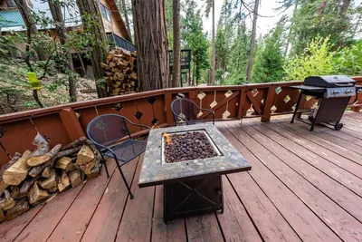 a deck with a grill and a table and chairs at A-Frame Escape Unique stay w comfort & style in Shaver Lake