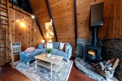 a living room with a couch and a fireplace at A-Frame Escape Unique stay w comfort & style in Shaver Lake