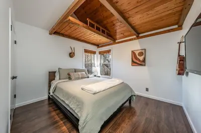 a bedroom with a bed and a wooden ceiling at Creekside Cabin - Pup-Friendly with AC in Shaver Lake