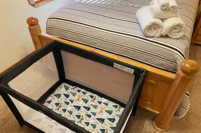 a small bed with a crib with a chessboard on it at The Elderberry Retreat - It's a Dream Location! in Shaver Lake