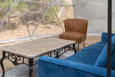 a living room with a couch and a table and a chair at Dome Sweet Dome | Shaver Lake in Shaver Lake
