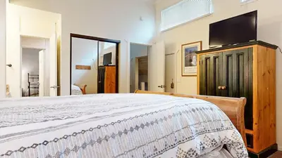 a bedroom with a bed and a flat screen tv at Summit #48 condo in Mammoth Lakes