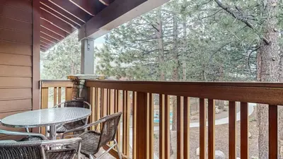 a patio with a table and chairs on a balcony at Summit #48 condo in Mammoth Lakes