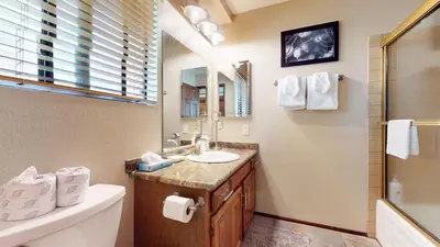 a bathroom with a sink and a toilet and a mirror at Snowflower #75 condo in Mammoth Lakes