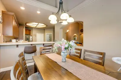 a dining room with a table with flowers in a vase at Clovis Retreat with Patio and Yard about 3 Mi to Old Town! in Clovis