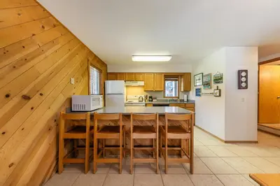 a kitchen with wooden cabinets and a table and chairs at Spacious 1br Condo w/Partial Lake View #117 at Donner Lake Village in Truckee