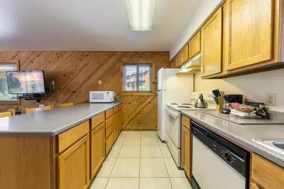a kitchen with wooden cabinets and a white refrigerator at Spacious 1br Condo w/Partial Lake View #117 at Donner Lake Village in Truckee