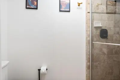 a bathroom with a shower with two pictures on the wall at Secluded Mtn Top Family Haven with Spa, Views & Arcade in Oakhurst