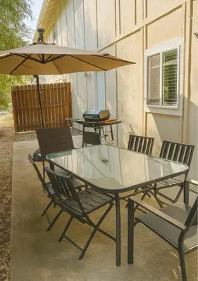 a glass table with two chairs and an umbrella at Comfort meets Tranquility by the Sequoia Entrance in Three Rivers